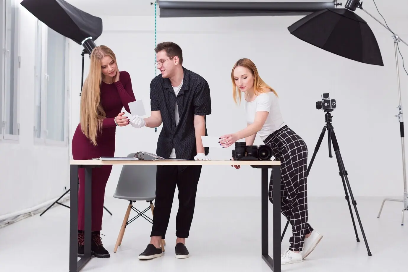 Frauen und ein Mann sehen im Studio Fotos durch.